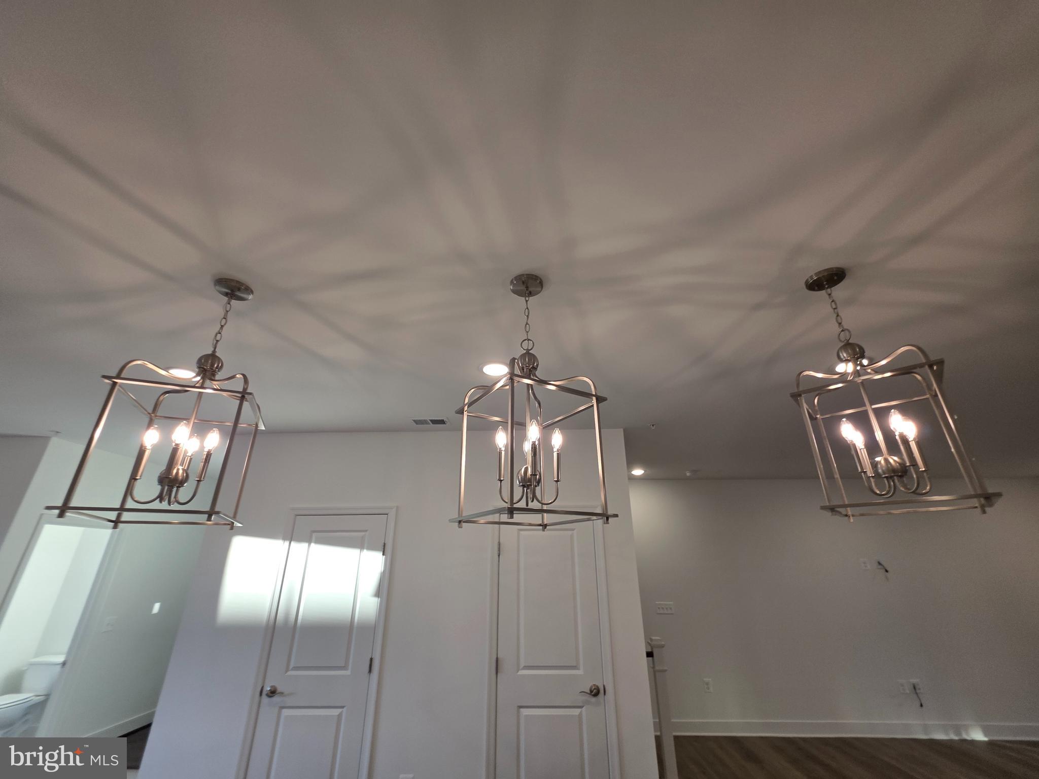 128 Locke Street, Unit B Baltimore, MD 21230 - Photo 24 of 49 an empty room with wooden floor chandelier fan and kitchen view