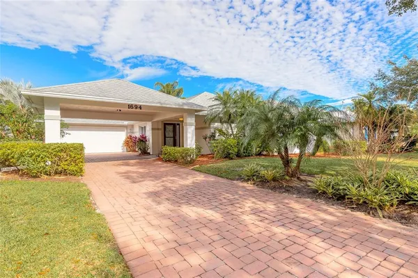 a view of a house with backyard and a tree