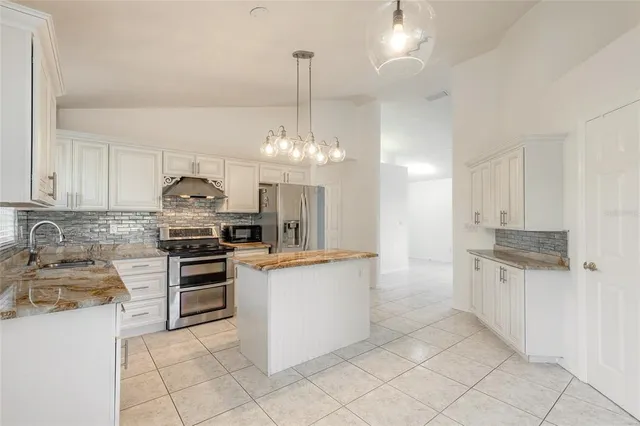 a kitchen with kitchen island granite countertop a stove and a shower