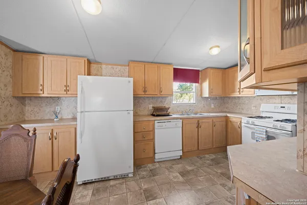 a kitchen with a sink a refrigerator a stove and cabinets