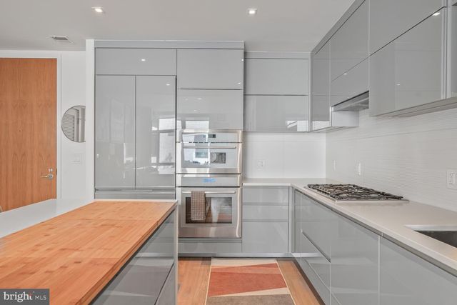 a kitchen with kitchen island a counter top space a stove and cabinets