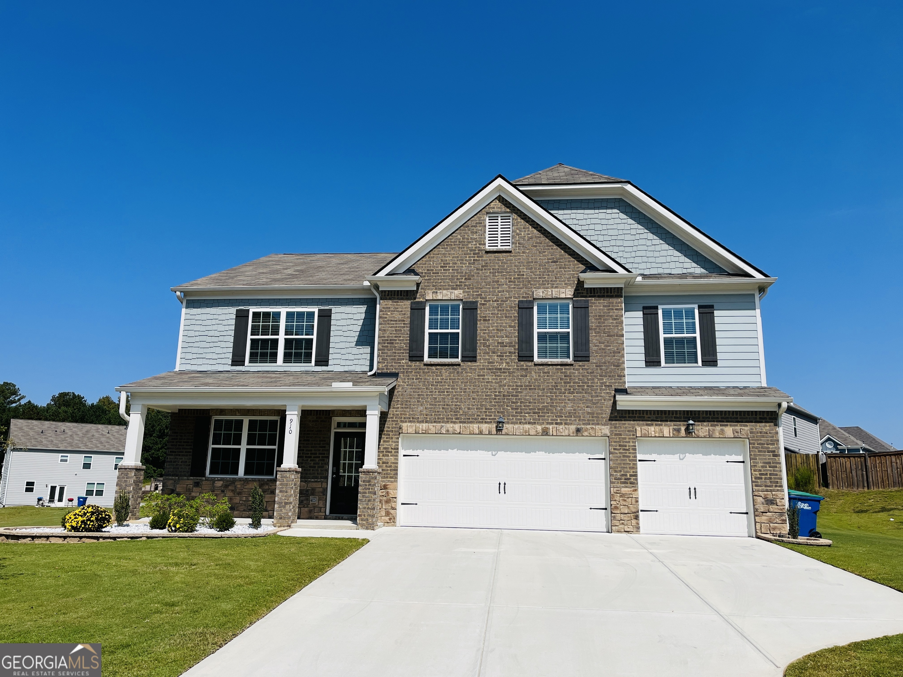 a front view of a house with a garden and yard
