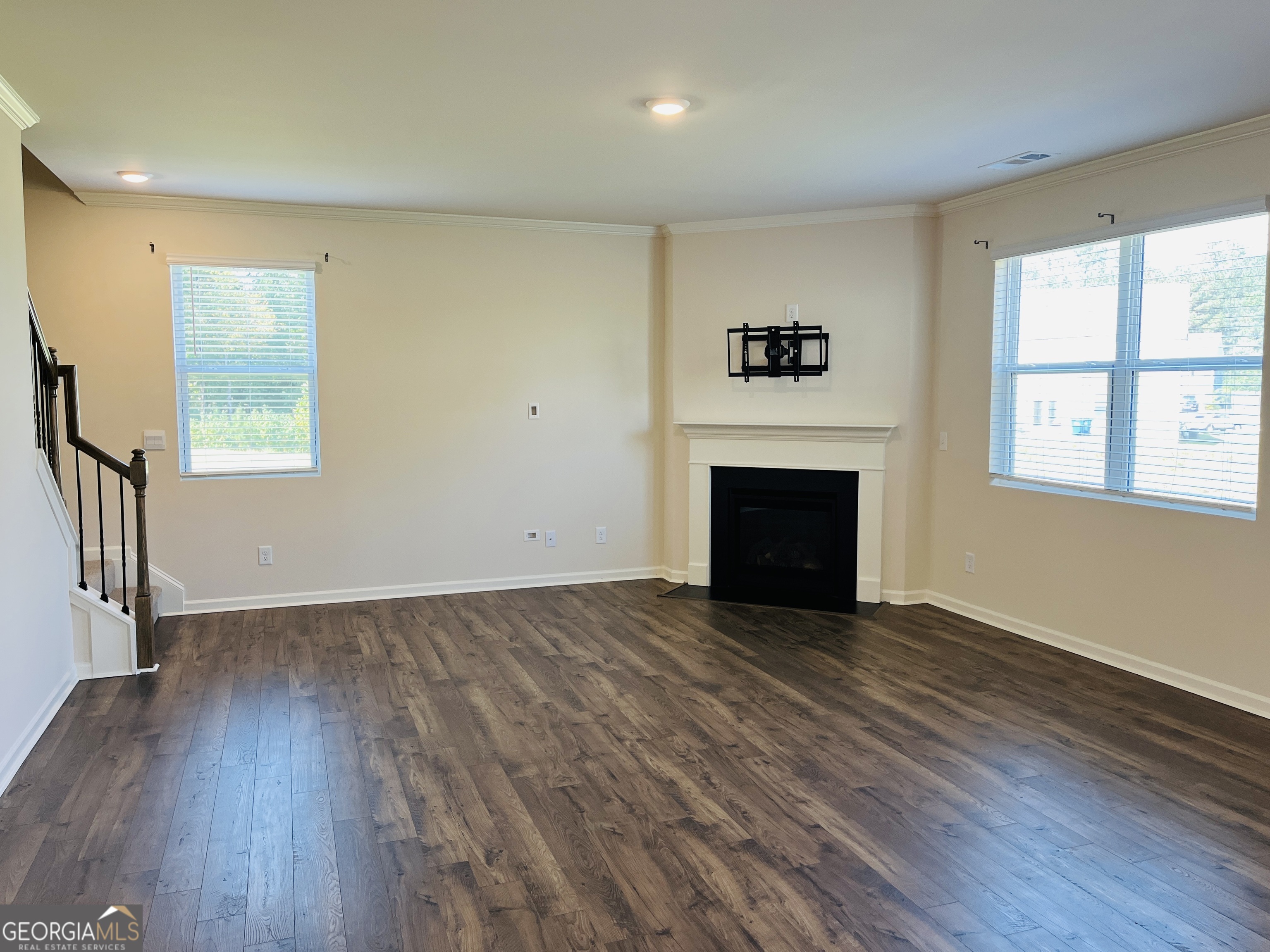 910 Sly Fox Run Fairburn, GA 30213 - Photo 11 of 46 an empty room with windows a fireplace and wooden floor