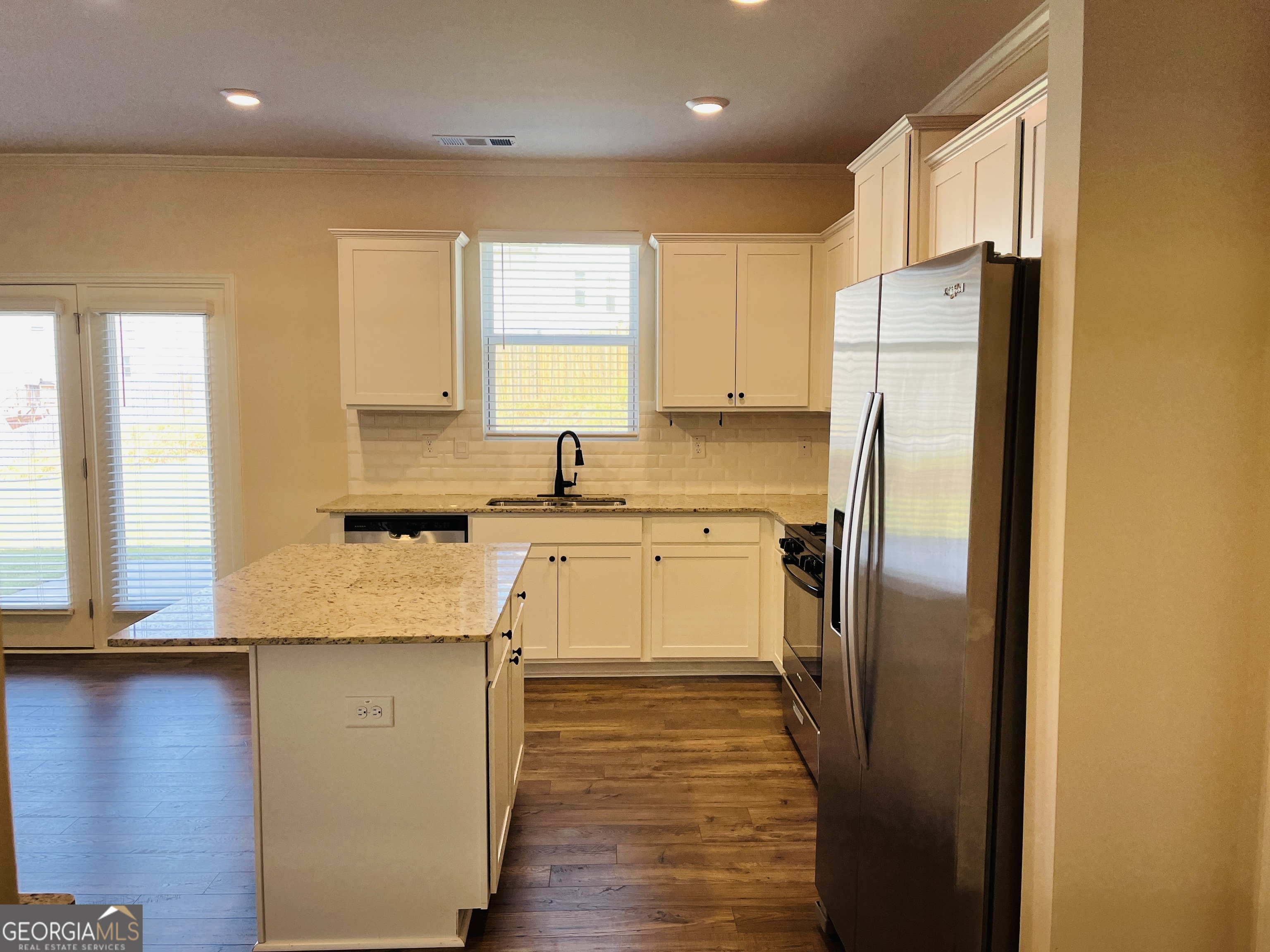 910 Sly Fox Run Fairburn, GA 30213 - Photo 14 of 46 a kitchen with stainless steel appliances granite countertop a refrigerator a sink and white cabinets