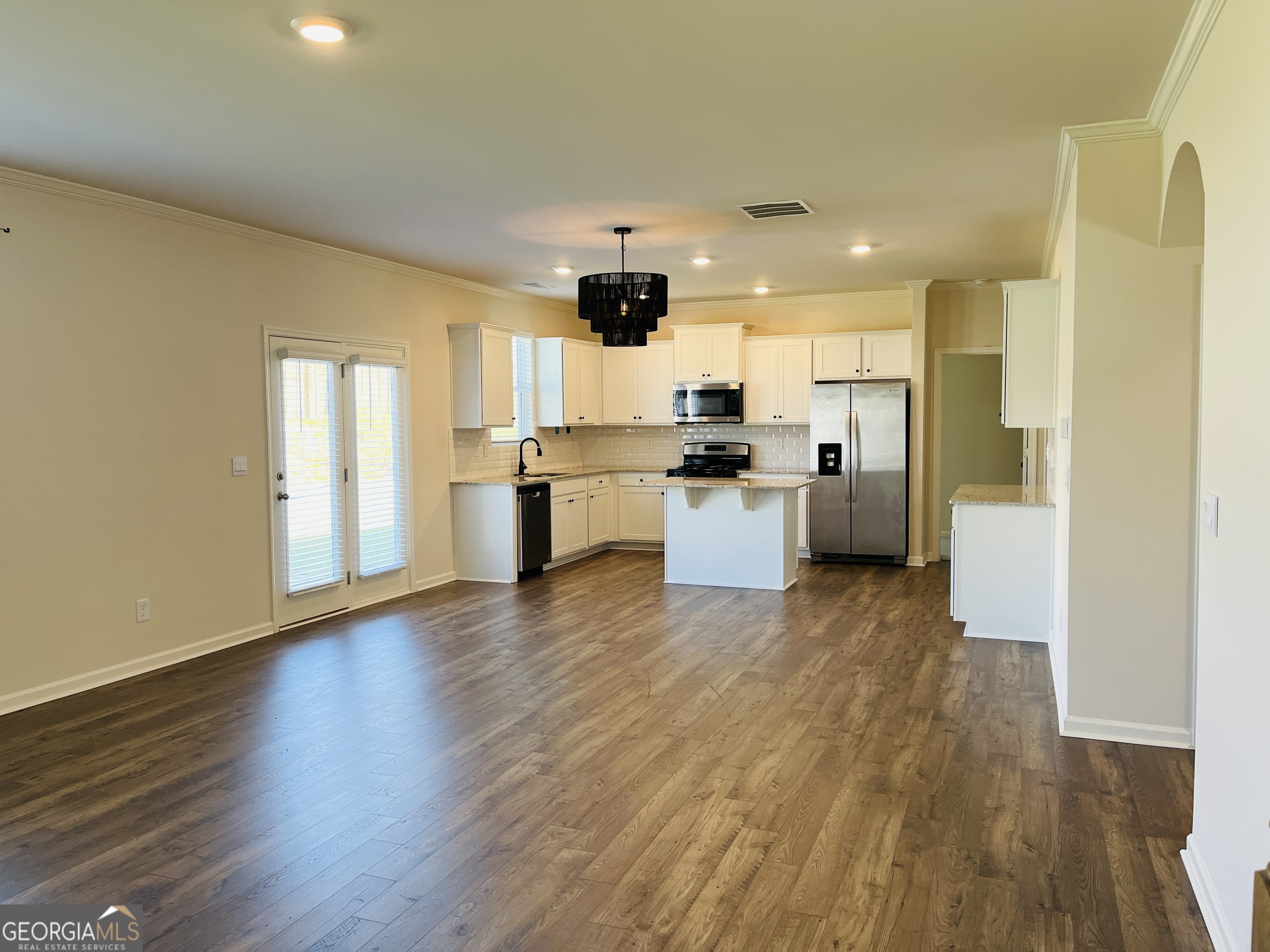 910 Sly Fox Run Fairburn, GA 30213 - Photo 8 of 46 a large kitchen with a wooden floor and stainless steel appliances