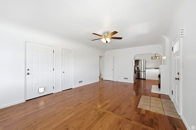 1925 South Main Street Bountiful, UT 84010 - Photo 10 of 48 Living area featuring wood-finish flooring, a ceiling fan with integrated lighting, and an arched doorway leading to the kitchen