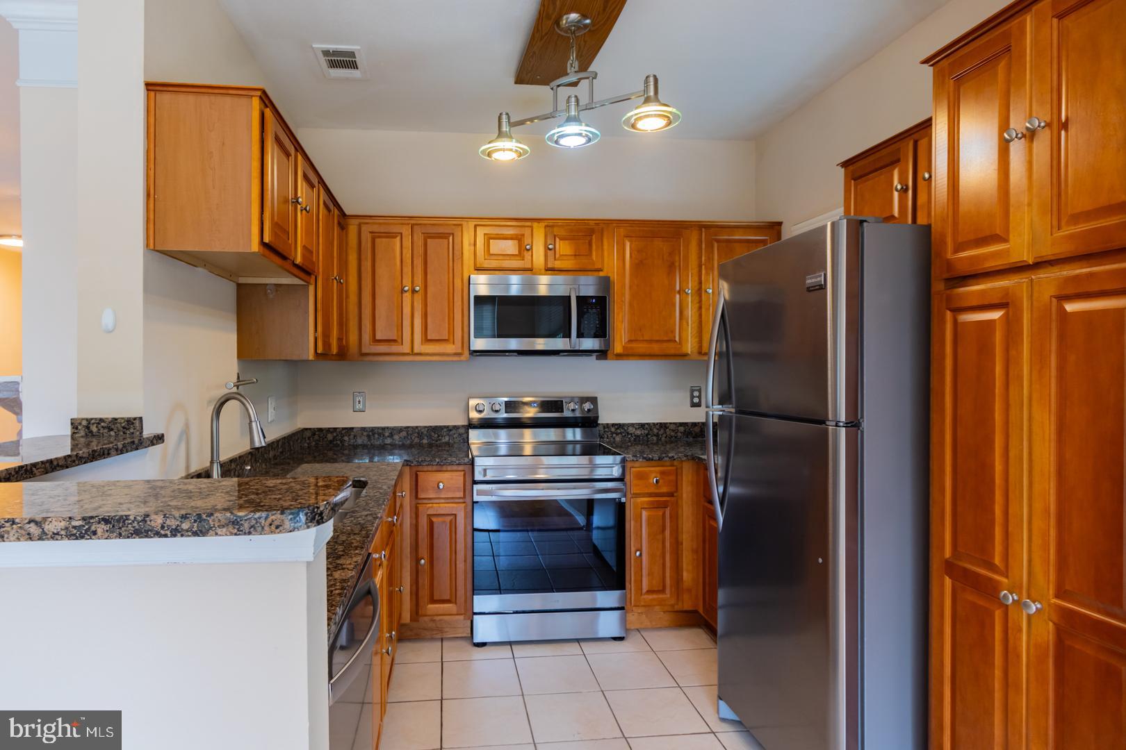 1600 Spring Gate Dr., Unit 2207 McLean, VA 22102 - Photo 7 of 32 a kitchen with stainless steel appliances granite countertop a refrigerator a stove a sink and a microwave