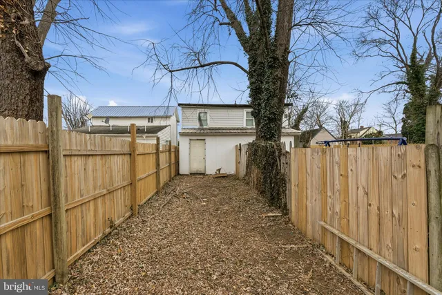 a view of a yard with wooden fence and trees