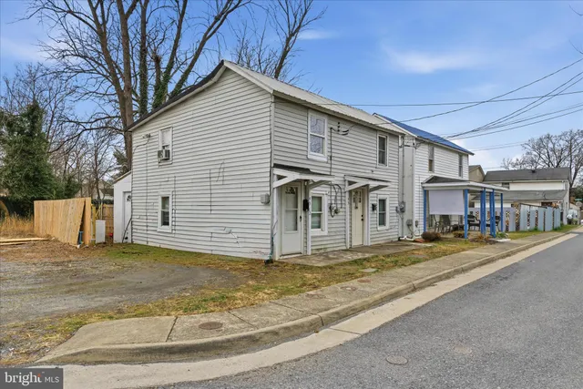 a view of a house with a big yard and large tree