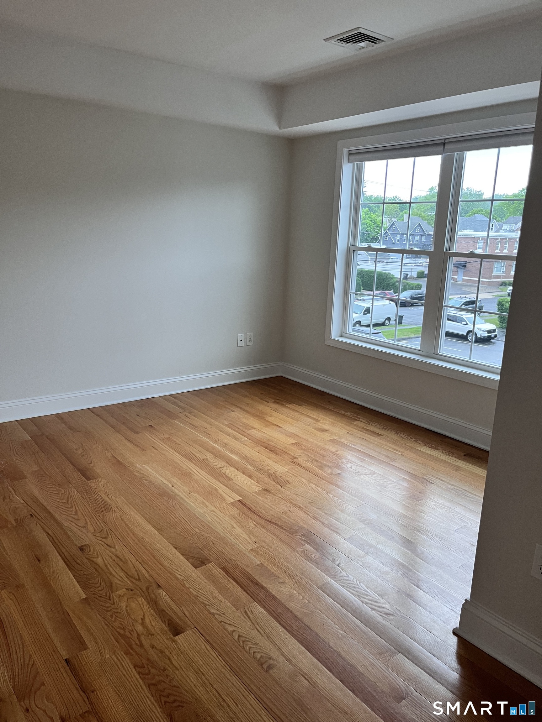 20 3rd Street, Unit 18 Stamford, CT 06905 - Photo 12 of 28 an empty room with wooden floor and windows