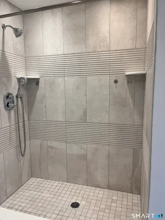 a bathroom with a granite countertop toilet sink and mirror