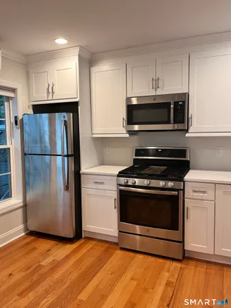a kitchen with granite countertop a refrigerator stove and microwave