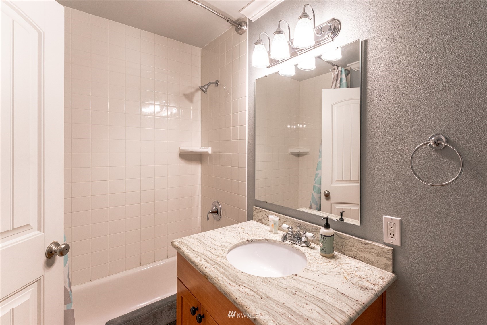 1902 West Prospect Street, Unit 112 Chelan, WA 98816 - Photo 25 of 40 a bathroom with a granite countertop sink a mirror and a shower