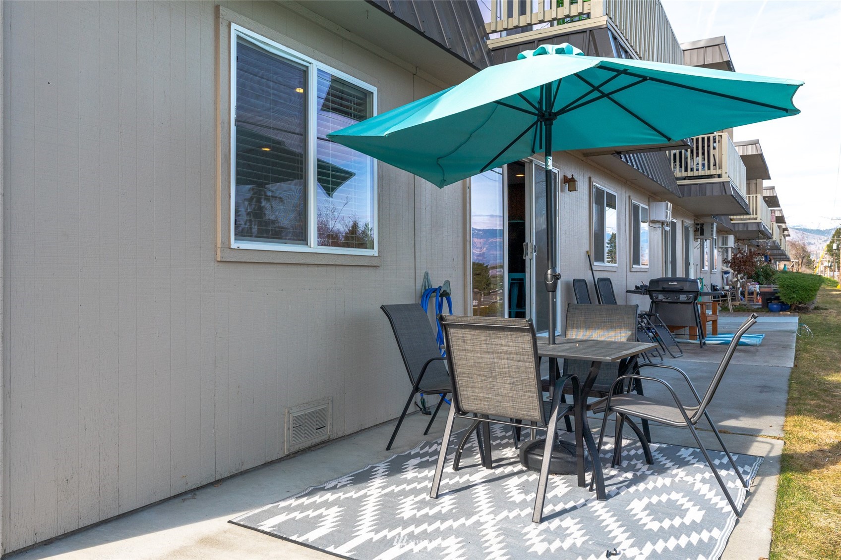 1902 West Prospect Street, Unit 112 Chelan, WA 98816 - Photo 29 of 40 a view of patio with chairs and table under an umbrella