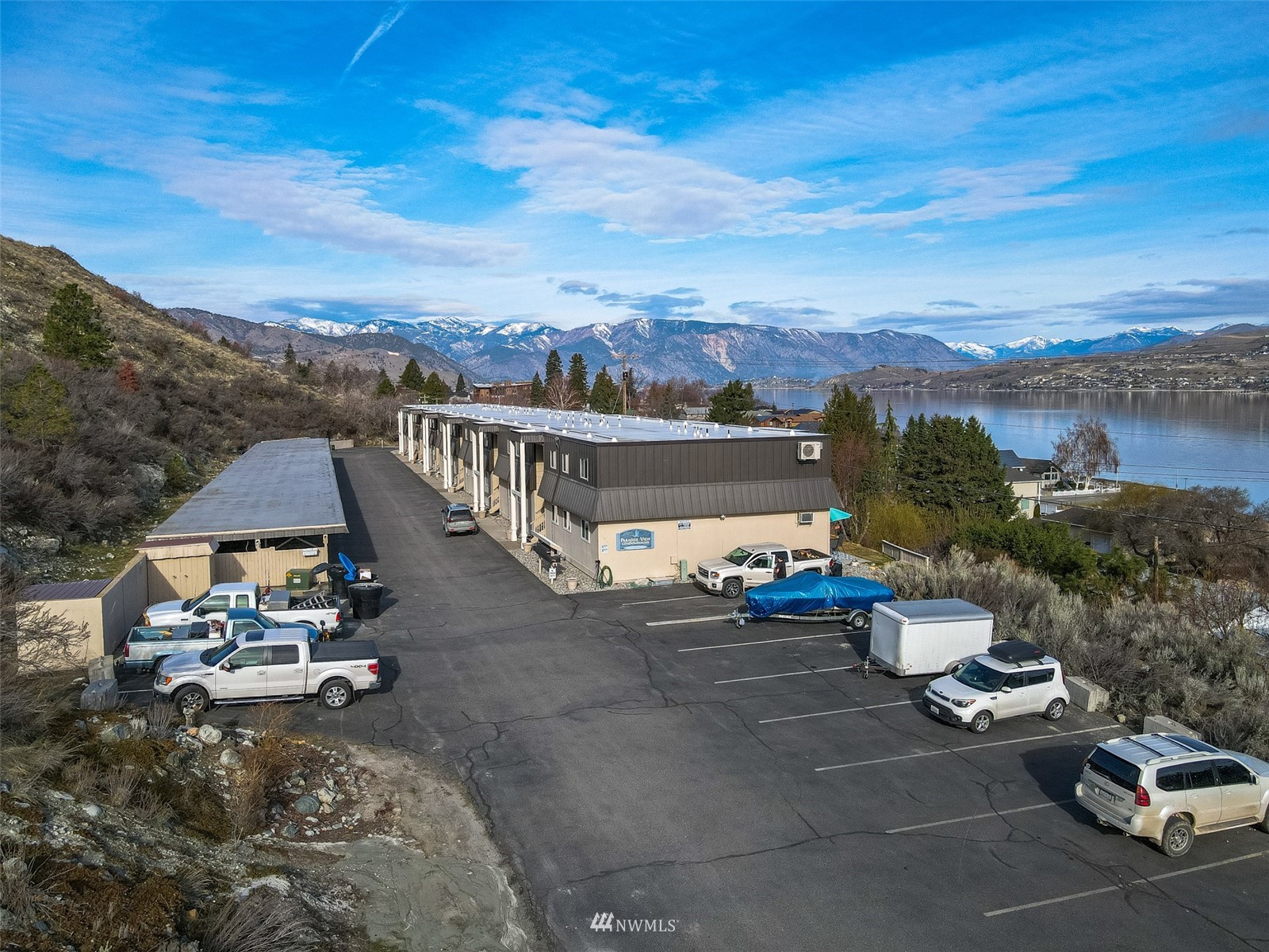 1902 West Prospect Street, Unit 112 Chelan, WA 98816 - Photo 37 of 40 a view of a patio with couches and table and chairs under an umbrella