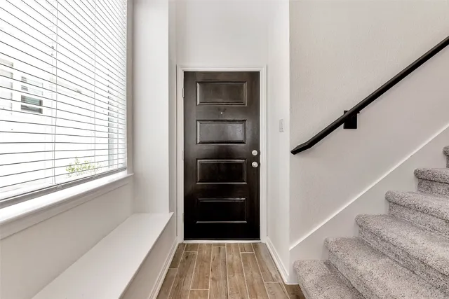 a view of a hallway view with wooden floor and staircase
