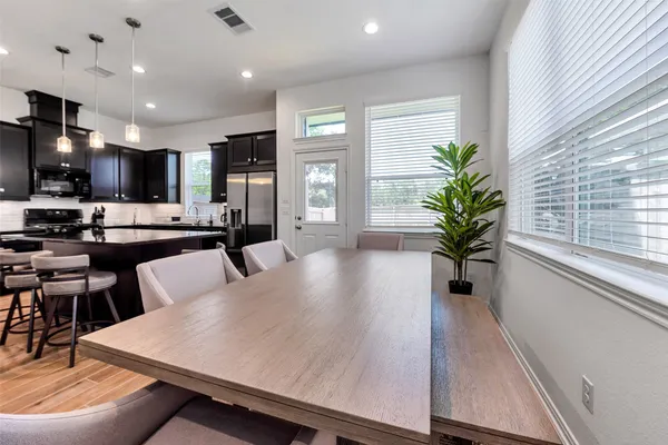 a large kitchen with a table and chairs