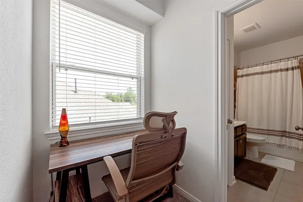 a view of a workspace with furniture and a window