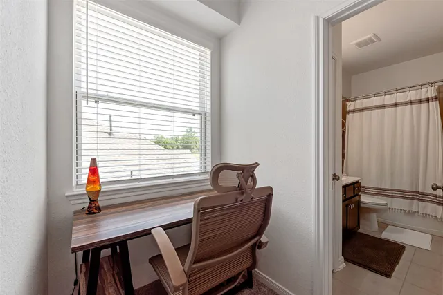 a view of a workspace with furniture and a window