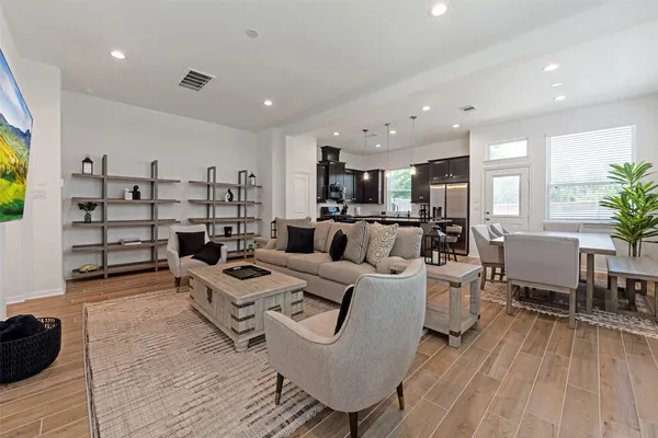 a living room with furniture and a wooden floor