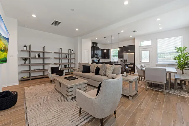 a living room with furniture and a wooden floor
