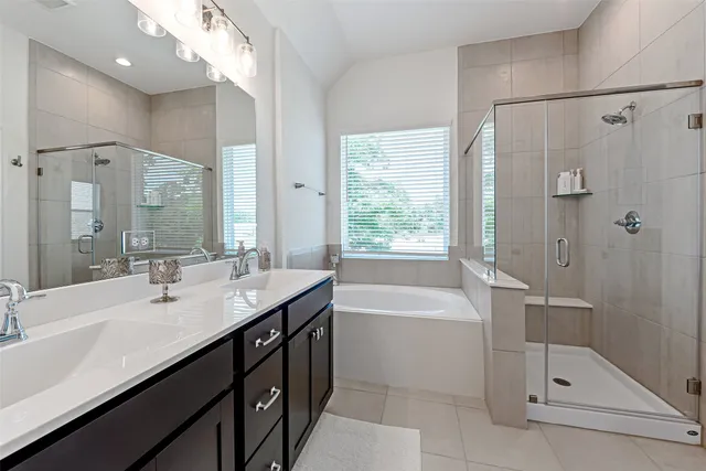 a bathroom with a tub sink shower and mirror