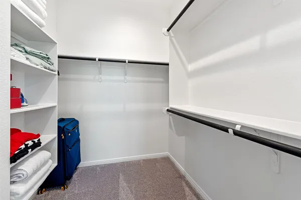 a view of walk in closet with clothes and shoes