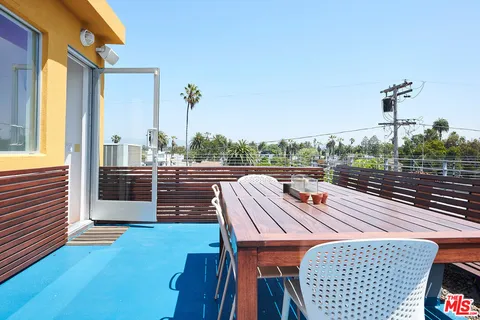 a view of a porch with a bench and floor to ceiling window