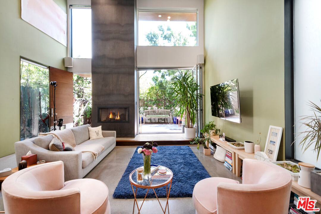 417 Venice Way Venice, CA 90291 - Photo 6 of 53 a living room with furniture a fireplace and a floor to ceiling window