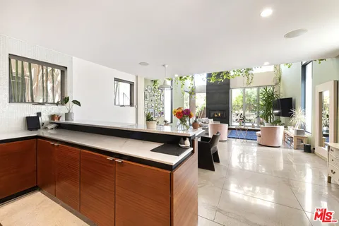 a living room with stainless steel appliances kitchen island granite countertop a sink and cabinets