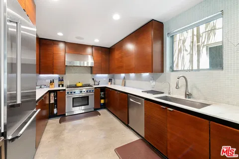 a kitchen with stainless steel appliances a sink stove and cabinets