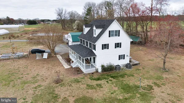 a kitchen with stainless steel appliances granite countertop a refrigerator a sink dishwasher a stove and white cabinets with wooden floor