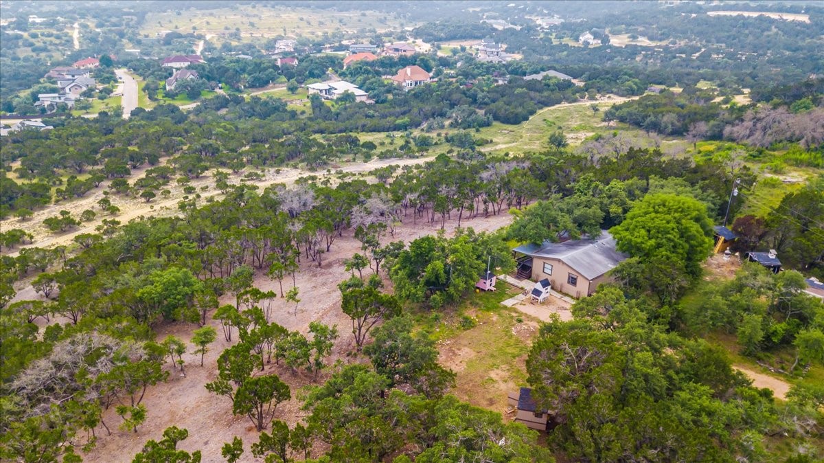 4519 Crawford Road Spicewood, TX 78669 - Photo 3 of 9 An aerial perspective reveals a secluded residence nestled amidst abundant mature trees, offering peaceful privacy.