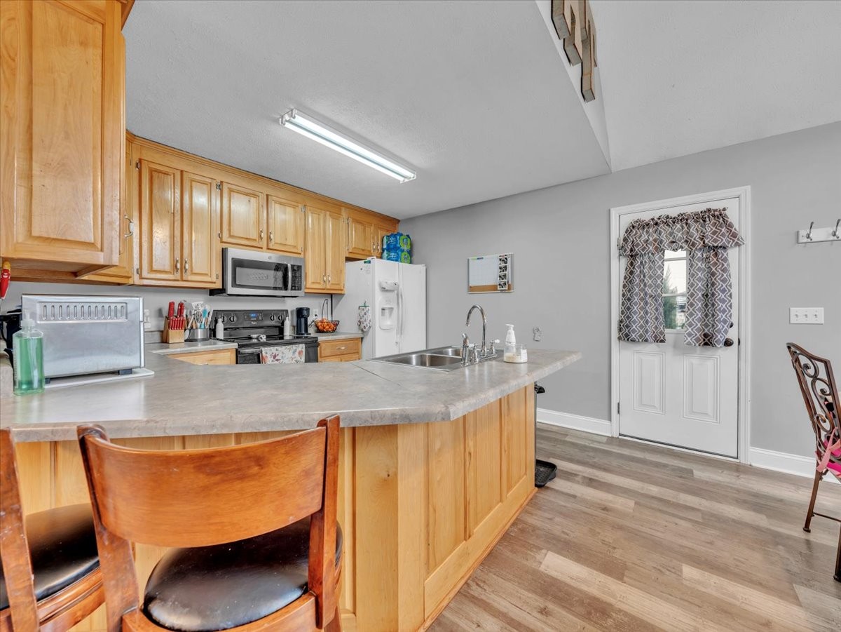 9 Merideth Lynn Road Fayetteville, TN 37334 - Photo 11 of 31 a kitchen with stainless steel appliances granite countertop a sink a stove and a wooden floors
