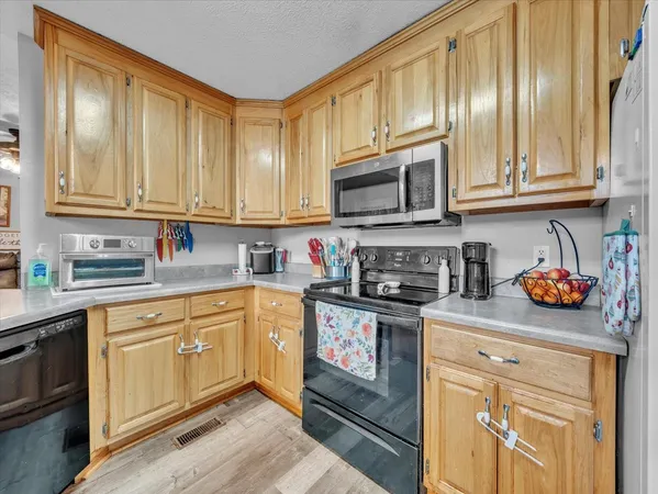 a kitchen with stainless steel appliances granite countertop a stove a sink dishwasher and a microwave oven with cabinets