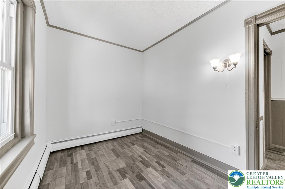 1128 Maple Street Bethlehem, PA 18018 - Photo 17 of 34 A well-lit, modest interior space with wood-look flooring awaits personalization.