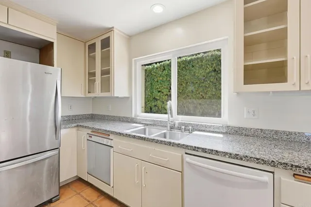 a kitchen with granite countertop a sink window and cabinets
