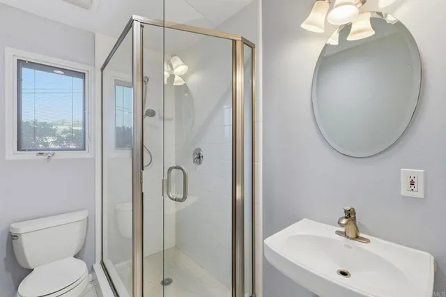 an aerial view of a city with lots of residential buildings and ocean view in back