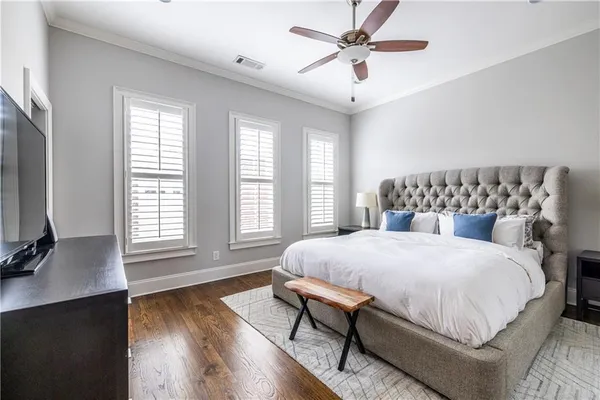 a bedroom with a large bed and wooden floor
