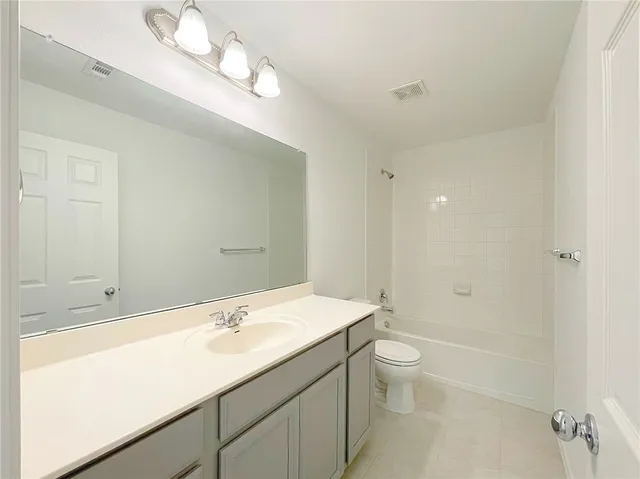 a spacious bathroom with a toilet sink and mirror