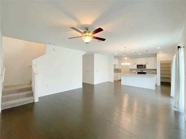 a view of a kitchen with kitchen island a sink stainless steel appliances and cabinets