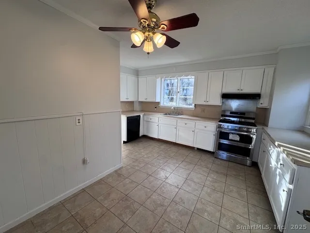 a kitchen with granite countertop a stove a sink and a refrigerator