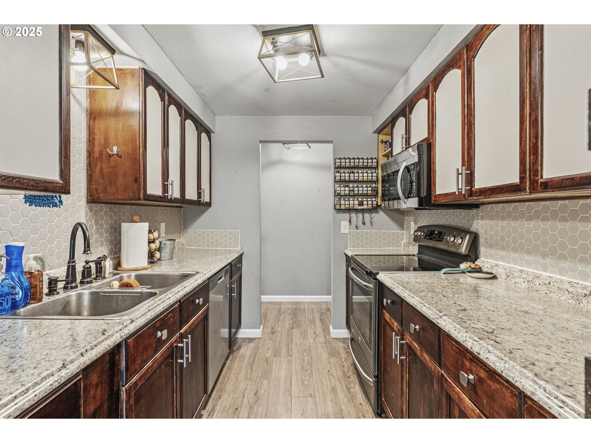 2634 34th Avenue Longview, WA 98632 - Photo 10 of 22 a kitchen with a sink dishwasher a stove top oven a refrigerator with wooden cabinets and floor