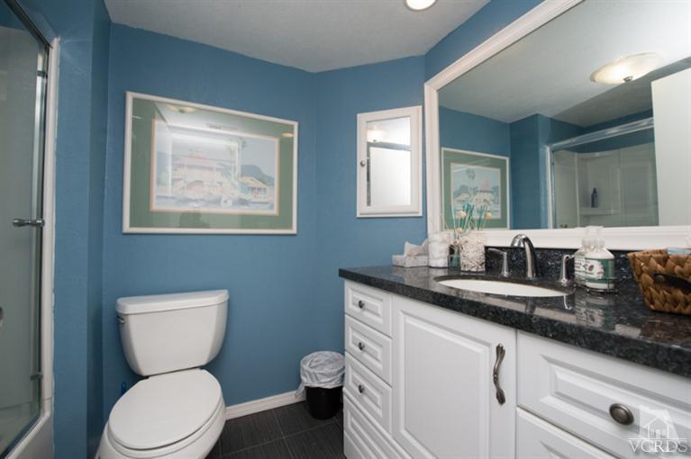 1718 Sinaloa Road, Unit 117 Simi Valley, CA 93065 - Photo 14 of 23 a bathroom with a toilet a sink and mirror