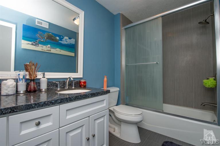 1718 Sinaloa Road, Unit 117 Simi Valley, CA 93065 - Photo 16 of 23 a bathroom with a granite countertop sink a toilet and a shower