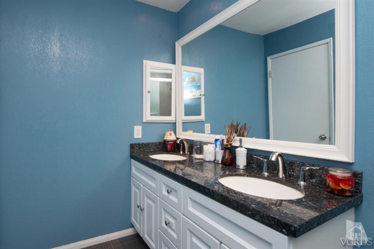 1718 Sinaloa Road, Unit 117 Simi Valley, CA 93065 - Photo 17 of 23 a bathroom with a granite countertop sink and a mirror