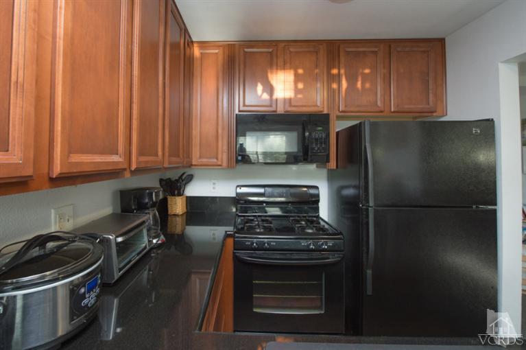 1718 Sinaloa Road, Unit 117 Simi Valley, CA 93065 - Photo 9 of 23 a kitchen with a stove and a refrigerator