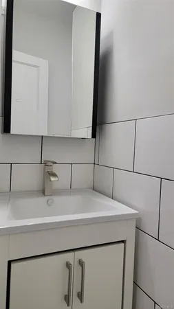 a bathroom with a sink and a refrigerator