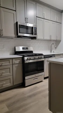 a kitchen with stainless steel appliances granite countertop a stove and a microwave