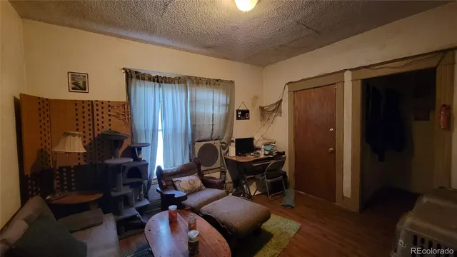 a living room with furniture a desk and chair with wooden floor
